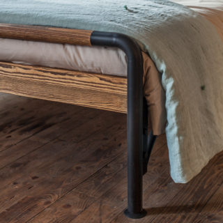Bett aus Holz mit Metall und Bettdecken