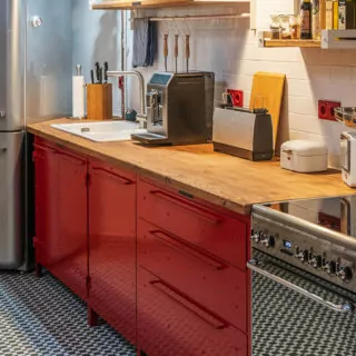 Arbeitsplatte aus Holz und Kundenküche im Industrial Design in rot